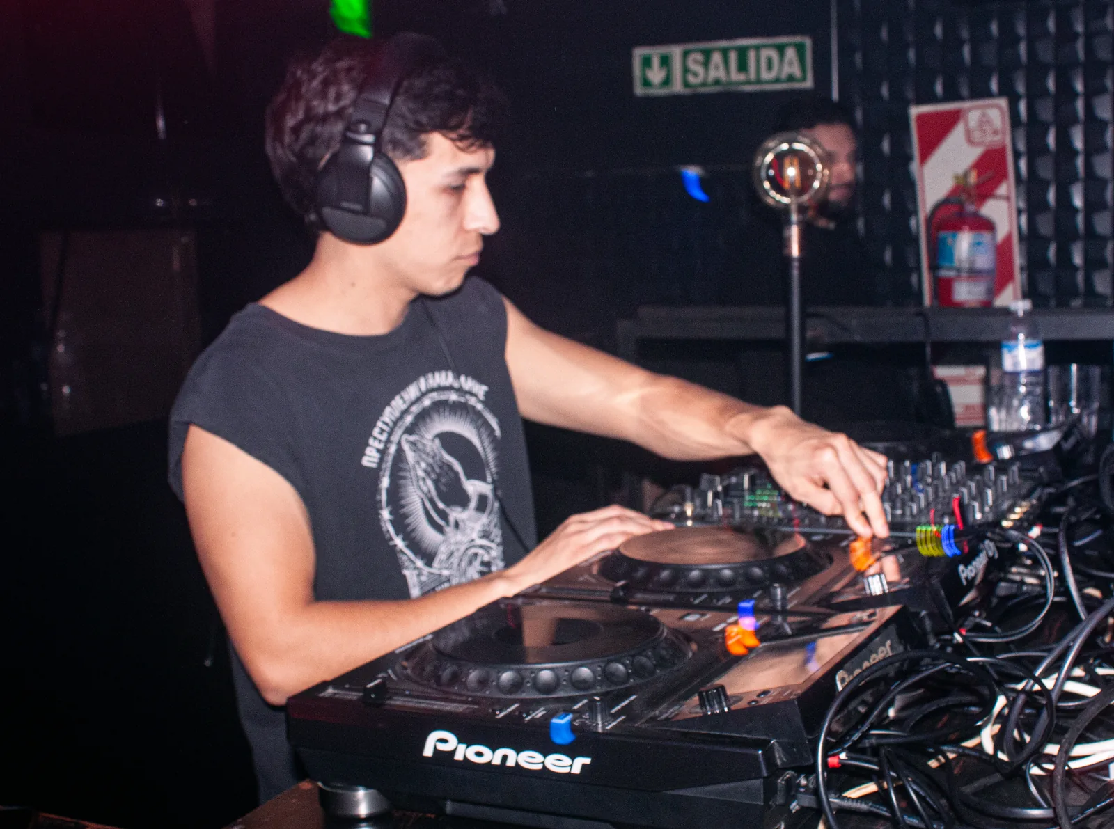N01111 en cabina, con auriculares, mezclando sobre CDJs Pioneer